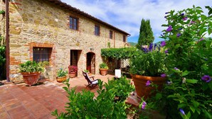 A stone building with a tiled patio, potted plants, and outdoor seating. - Vivaia Arceno Rentals Club, Villa in Chianti , exclusive Pool Concierge freeWiFi (San Gusmè)