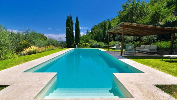 A rectangular swimming pool with a clear blue water surface, surrounded by a well-maintained lawn and a pergola with outdoor seating. - Vivaia Arceno Rentals Club, Villa in Chianti , Exclusive Pool Concierge Freewifi (San Gusmè)