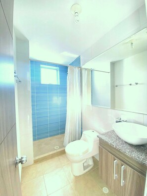 Apartamento família | Banheiro | Chuveiro, chuveiro com efeito de chuva, toalhas de banho, sabonete