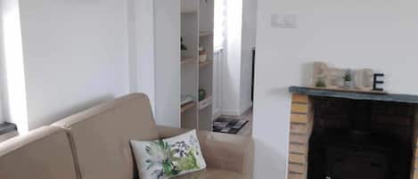Ein Wohnzimmer mit einem beigen Sofa, einem Kamin und einem an der Wand montierten Fahrrad.