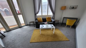 A modern living room with a sofa, a coffee table, and a yellow rug. - Best Priced Apartment In Danum  19 (Doncaster)