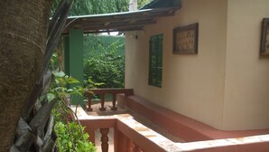 A covered outdoor area with a tiled floor, a bench, and a railing. - Camping-Sukuta & Lodge (Serrekunda)