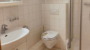 A bathroom with a sink, toilet, and shower. - Apartment Brockenblick in the Harz Mountains - Pool & Sauna (Braunlage)