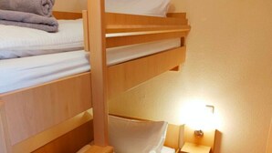 A bunk bed room with a bedside table and lamp. - Apartment Brockenblick in the Harz Mountains - Pool & Sauna (Braunlage)