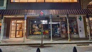 A hotel with a modern facade, large windows, and a prominent neon sign. - M383 Hotel Bariloche (San Carlos de Bariloche)