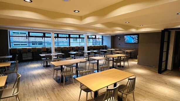 A spacious dining area with multiple tables and chairs, large windows, and recessed ceiling lights. - M383 Hotel Bariloche (San Carlos de Bariloche)