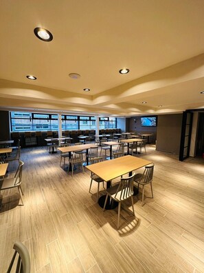A spacious dining area with multiple tables and chairs, large windows, and recessed ceiling lights. - M383 Hotel Bariloche (San Carlos de Bariloche)