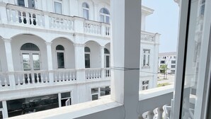 A white building with balconies and arched windows. - Phu My An Apartment Hue (Hue)