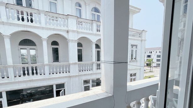 A white building with balconies and arched windows. - Phu My An Apartment Hue (Hue)