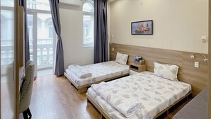 A hotel room with two beds, a desk, a chair, a window with curtains, and a ceiling light. - Phu My An Apartment Hue (Hue)