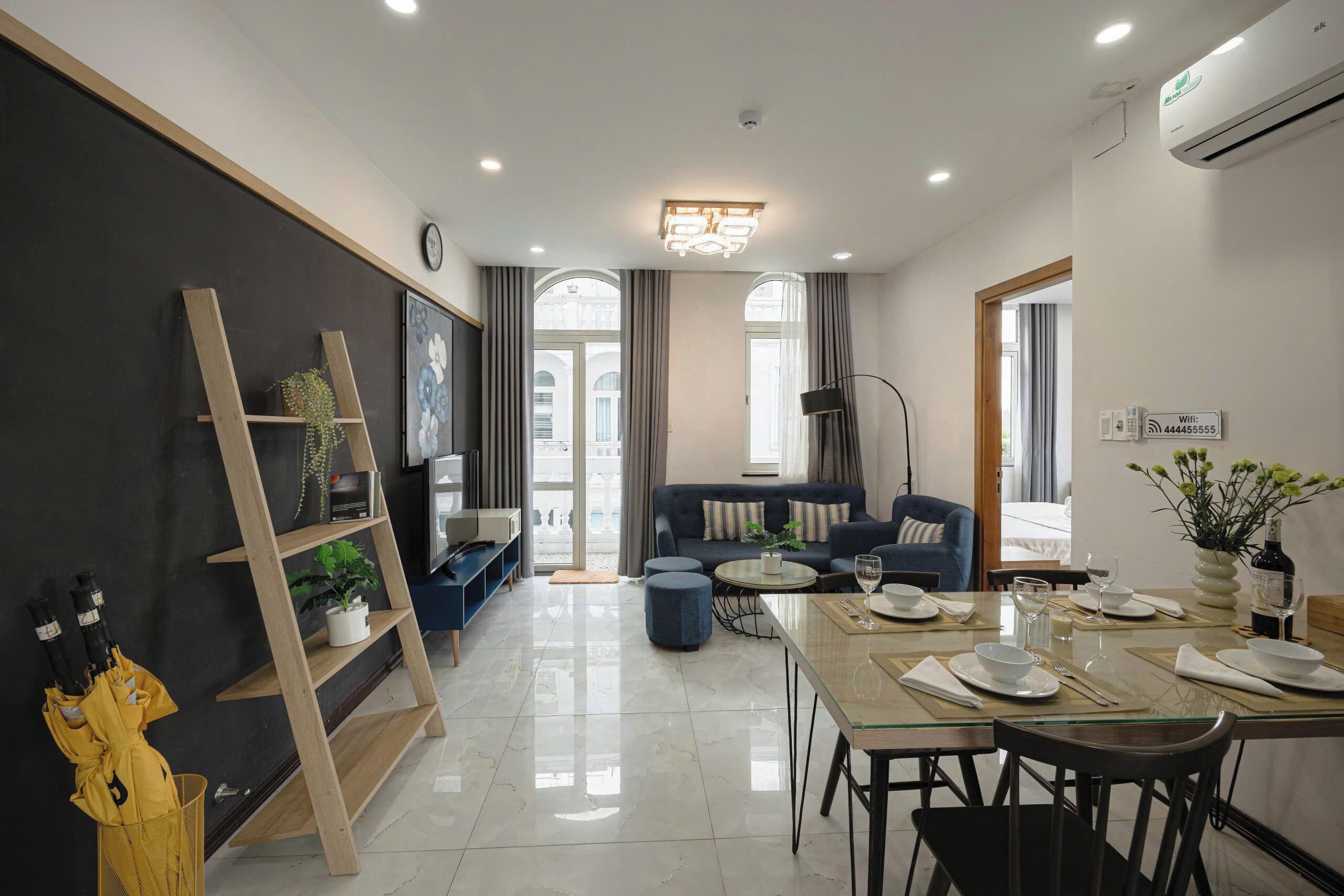 Una sala de estar moderna con un sofá, una mesa de comedor para dos personas y un televisor.
