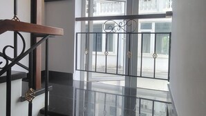 A staircase with a black railing leading to a balcony with a glass door. - Phu My An Apartment Hue (Hue)