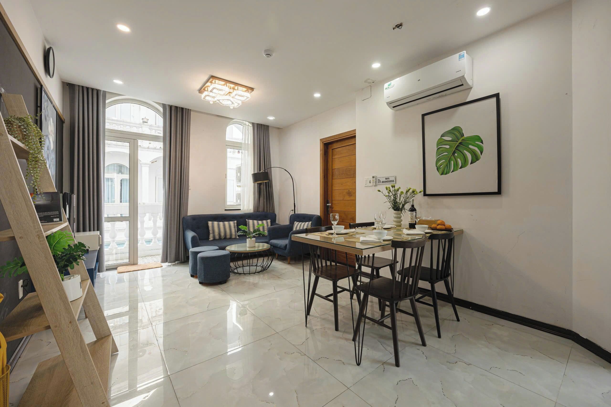 Una sala de estar moderna con un sofá, una mesa de comedor con sillas y una escalera con una planta.