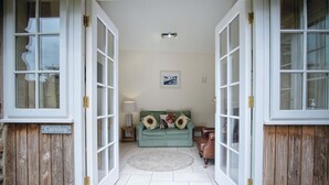 A cozy entrance with a green sofa, a small table with a lamp, and a framed picture on the wall.
