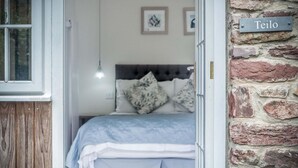 Ein Schlafzimmer mit einem Bett, Kissen und einem Schild mit der Aufschrift 'Teilo'.