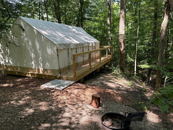 A rustic cabin with a wooden deck and a fire pit. - Valley Overlook, in heart of Cuyahoga Valley National Park - Glamping Tent S1 (Akron)
