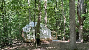 A cabin in a forest with a wooden deck and a small outdoor area. - Valley Overlook, in heart of Cuyahoga Valley National Park - Glamping Tent S1 (Akron)