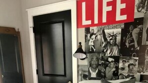 A bedroom with a bed, pillows, a door, and a wall with photos. - Binghamton's Beautiful Riverside Drive Living!
 (Binghamton)