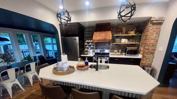 A modern kitchen with a large island, bar stools, a refrigerator, stove, and a microwave. - Binghamton's Beautiful Riverside Drive Living!
 (Binghamton)
