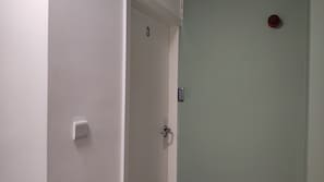 A closed door with a keypad lock, a light switch, and a small number '3' sign on the wall. - Stylish 1-Bed Flat | Free Parking · Netflix · In-Unit Laundry (Wigan,)