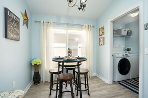 Cozy room with a dining area, seating space, and washing machine.