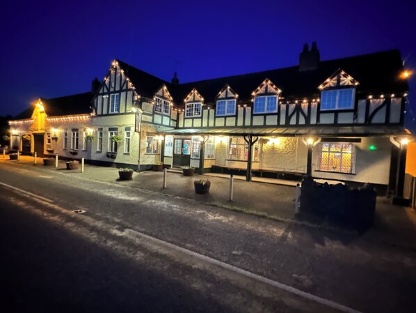 A traditional building with multiple windows and a covered entrance area, likely a hotel or pub.