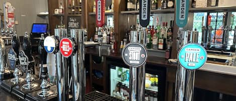 A bar with multiple taps, including brands like HPA, Butty Bach, and Camden.