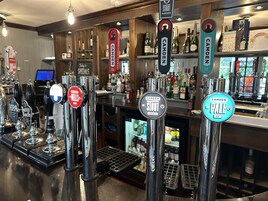A bar with multiple taps, including brands like HPA, Butty Bach, and Camden.