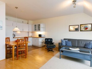 Un appartement moderne comprenant une cuisine, un coin repas et un salon.