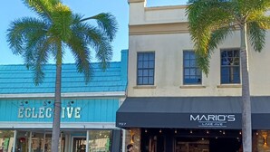 A street view with a blue storefront named 'ELECTIVE' and a restaurant named 'MARIO'S LAKE AVE'. - Historical Cottage in Downtown Lake Worth Beach, fully renovated and modernized (Lake Worth)