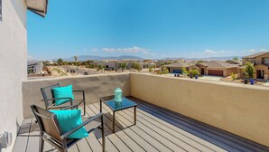 A balcony with outdoor furniture, a clear view of a residential area, and a mountain in the distance. - New Studio, Balcony w/views, Nexflix, Pool
 (Albuquerque)