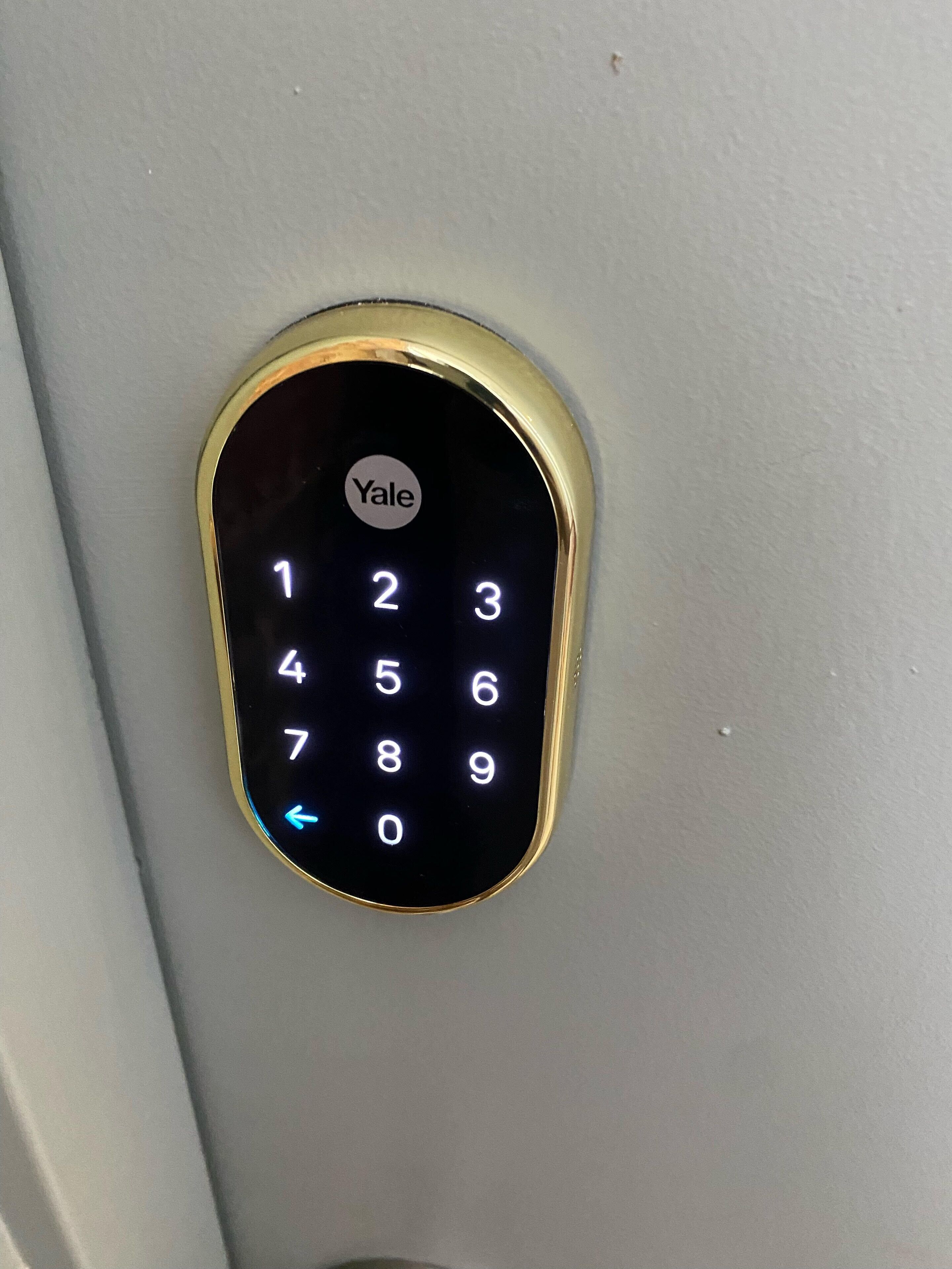 Teclado numérico com a marca Yale fixado numa parede.