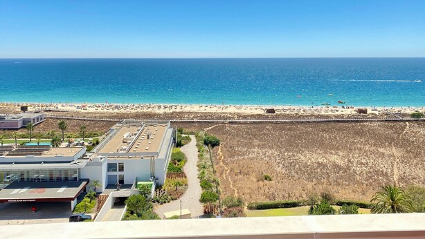 A coastal view with a beach, a building labeled "Pestana Alvor South Beach," and a clear sky.