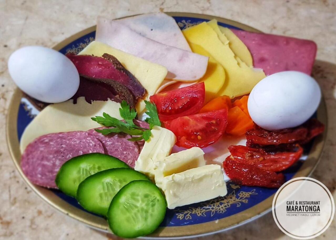 A charcuterie board with various meats, cheeses, and vegetables.
