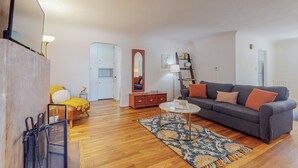 Ein Wohnzimmer mit Sofa, Couchtisch, Teppich und Spiegel.