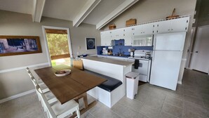 A modern kitchen with white cabinets, a wooden dining table, and a built-in oven. - Lake Front w/ Sunset Views, Screened-in Porch / 1x Boat Slip / 2x Kayaks (Jasper)