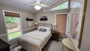 A bedroom with a bed, bedside tables, a ceiling fan, and windows. - Lake Front w/ Sunset Views, Screened-in Porch / 1x Boat Slip / 2x Kayaks (Jasper)