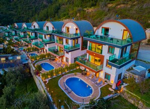 A modern resort with multiple guest rooms, a central pool, and a lush surrounding landscape. - Alanya Luxury Villas  (Antalya)