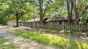 A row of single-story cabins with a wooden fence, surrounded by trees. - Lake House Landing w/ view of sailboat cove, quiet street (Garfield)