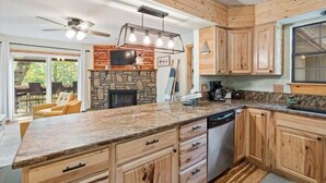 A kitchen with wooden cabinets, a granite countertop, a built-in stove, and a ceiling fan. - Lake House Landing w/ view of sailboat cove, quiet street (Garfield)