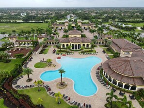 A large resort with a central swimming pool, multiple villas, and a well-maintained landscape.
