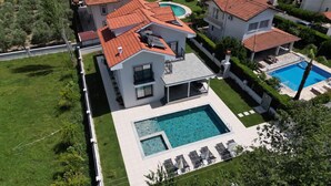 A modern two-story house with a swimming pool, a covered patio, and a well-maintained lawn. - Safe, central, lux and comfortable holiday in Dalyan. (Dalyan)