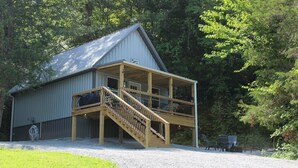 A two-story building with a covered porch and a staircase leading to the upper level.