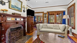 A living room with a fireplace, sofa, and a patterned rug.