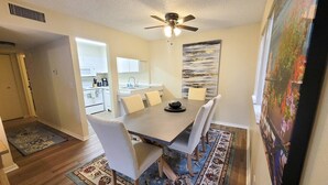 A dining area with a table, chairs, a ceiling fan, and a rug. - Large 1 BR Condo - Next to Oaks Mall and Hospital (Gainesville)
