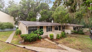 A single-story house with a front porch, a small yard, and a garage.
