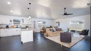 A spacious living area with a kitchen, a dining area, and a seating area with a couch and chairs. - New Home- Sleeps 8 -Near Gainesville & Springs (High Springs)