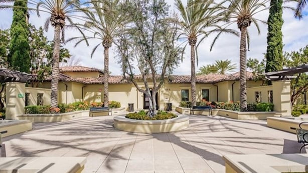 A courtyard with palm trees, a central fountain, and a building with a tiled roof. - Location! Location!  Woodbury-Walking to Shopping and Activities 步行到商圈，活動中心 (Irvine)