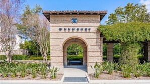 A stone archway with the inscription "WOODBURY" and a logo above it. - Location! Location!  Woodbury-Walking to Shopping and Activities 步行到商圈，活動中心 (Irvine)