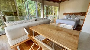 Una habitación moderna con una mesa de madera, un sofá y una cama.